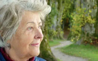 Zufriedene Rentnerin draußen in der Natur.