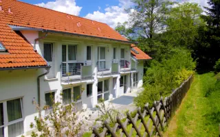 Rückansicht der Wohngemeinschaft mit Balkone und Terrassen im schönen Grün.
